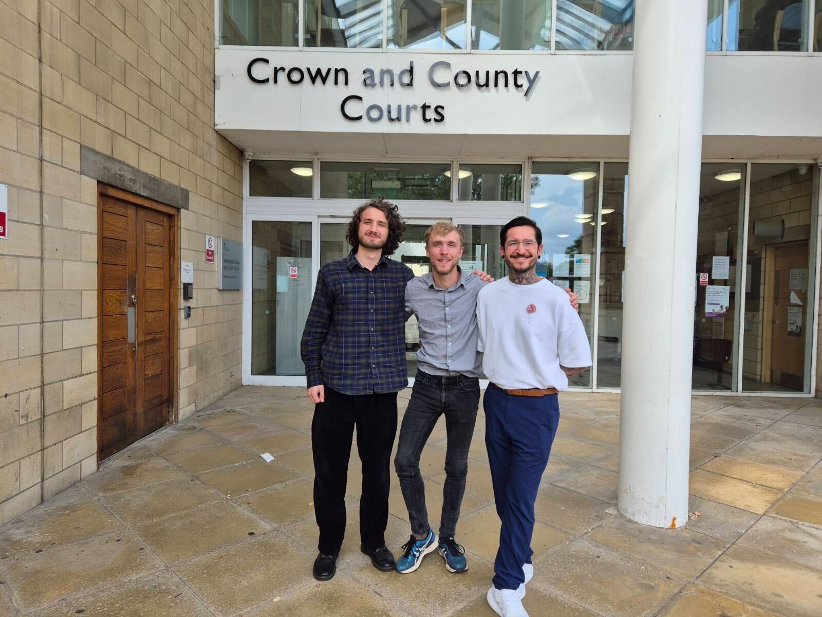 Three supporters of Animal Rising standing outside of Northampton Crown Court