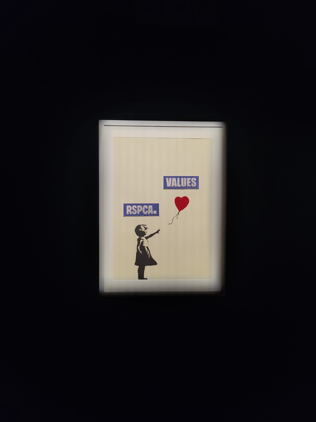 Banksy's Girl with Balloon is edited with stickers depicting the girl as the RSPCA and the red balloon as VALUES floating away